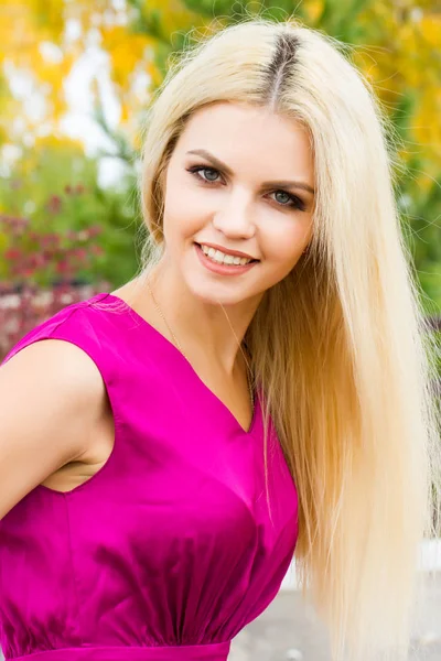 Sarı sonbahar yaprakları çerçevede bir parlak elbiseli genç sarışın