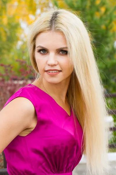 Sarı sonbahar yaprakları çerçevede bir parlak elbiseli genç sarışın