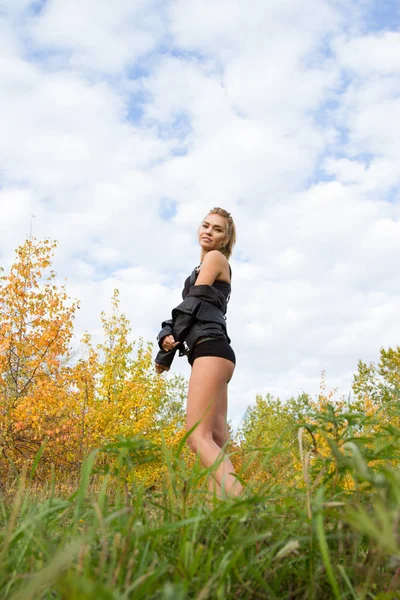 Kız siyah deri ceket ve iç çamaşırı sonbahar orman arka planı