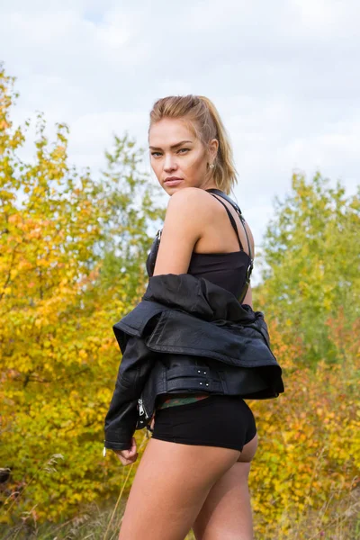 Fille en veste en cuir noir et lingerie sur fond de forêt d'automne — Photo