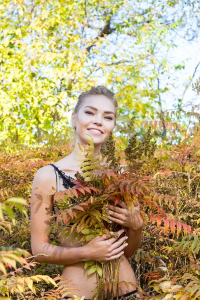 Сексуальная девушка в кружевном белье среди желтых осенних листьев — стоковое фото