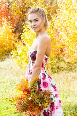 Sarı yapraklar ormanda yürüyüş bir buket ile genç kız