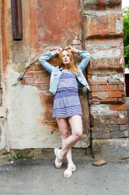 kısa etekli kız eski bir ev tuğla duvar tarafından duruyor