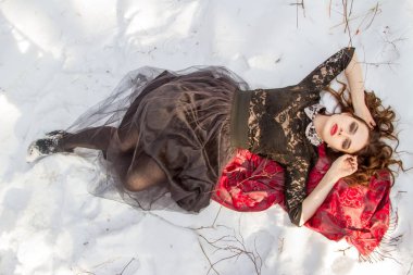 kar üzerinde parlak bir makyaj kızla yatıyor
