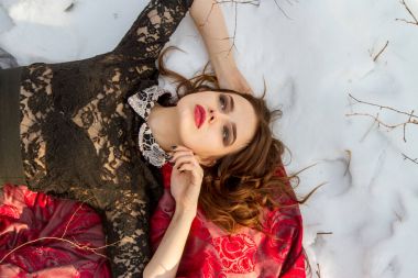 kar üzerinde parlak bir makyaj kızla yatıyor