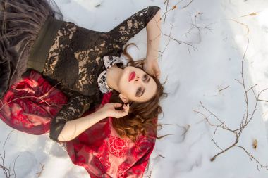 kar üzerinde parlak bir makyaj kızla yatıyor