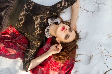 kar üzerinde parlak bir makyaj kızla yatıyor