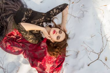 kar üzerinde parlak bir makyaj kızla yatıyor