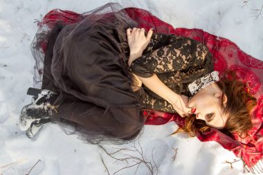 kar üzerinde parlak bir makyaj kızla yatıyor