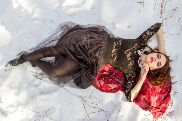 Mädchen mit hellem Make-up liegt im Schnee — Stockfoto