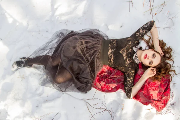 kar üzerinde parlak bir makyaj kızla yatıyor