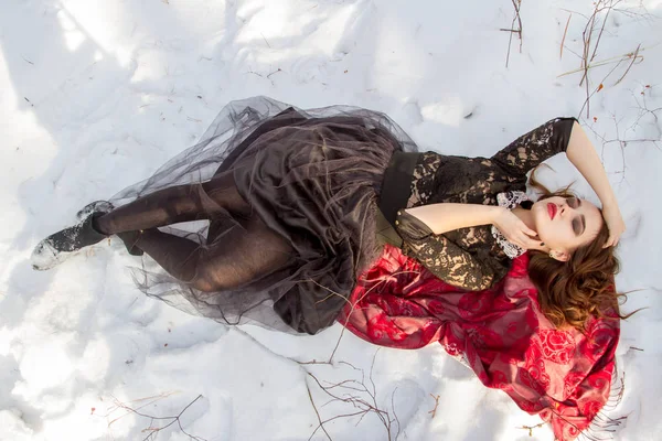 kar üzerinde parlak bir makyaj kızla yatıyor