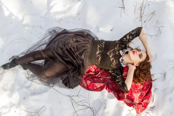 Mädchen mit hellem Make-up liegt im Schnee — Stockfoto