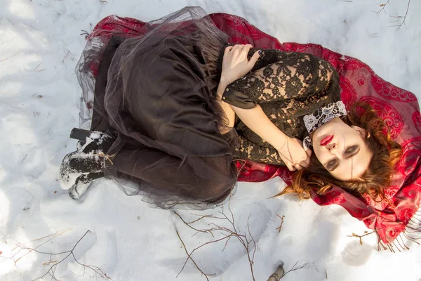 kar üzerinde parlak bir makyaj kızla yatıyor