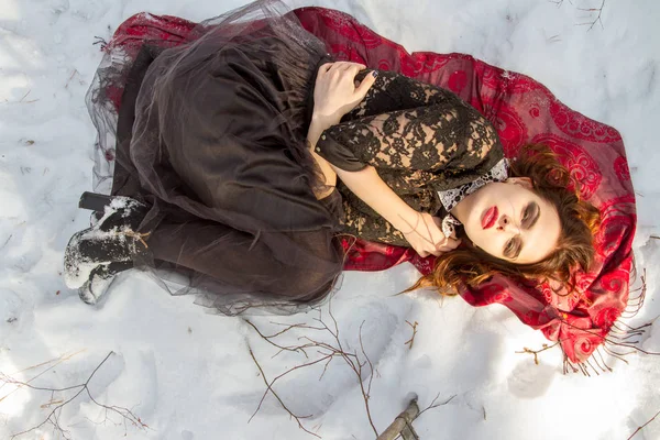 Mädchen mit hellem Make-up liegt im Schnee — Stockfoto