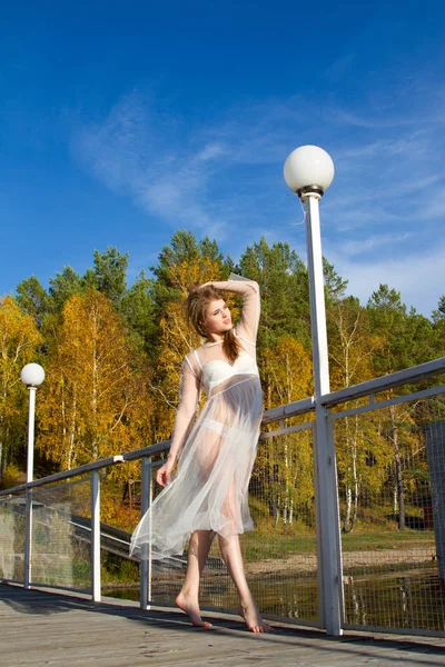 Meisje in een transparante jurk loopt langs de schilderachtige oevers van de vijver — Stockfoto