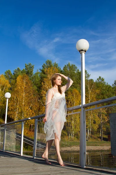 Meisje in een transparante jurk loopt langs de schilderachtige oevers van de vijver — Stockfoto