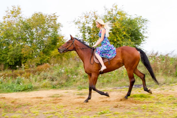 Junge Blondine reitet Pferd springt am Ufer der Bucht entlang — Stockfoto