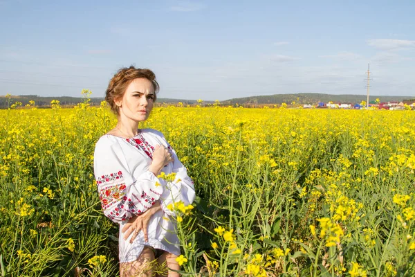 Kız çiçek açan alan arasında işlemeli bir gömlek