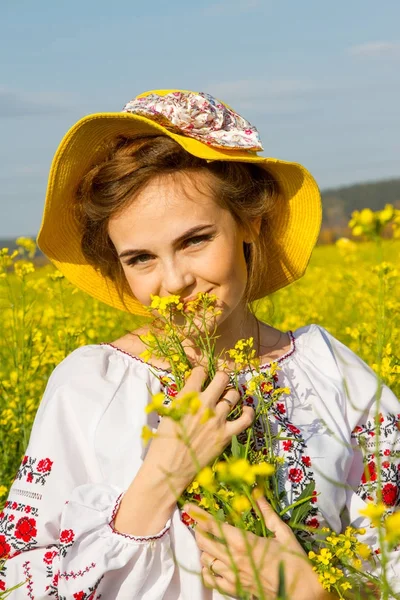 Girl in an embroidered shirt among the blooming field — Stock Photo, Image