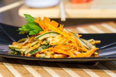 Üzerinde siyah bir tabak deniz ürünleri ile sebze salatası