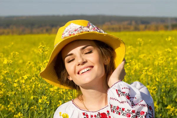 Girl in an embroidered shirt among the blooming field — Stock Photo, Image