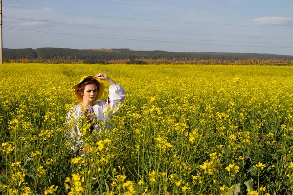 Девушка в вышитой рубашке среди цветущего поля — стоковое фото