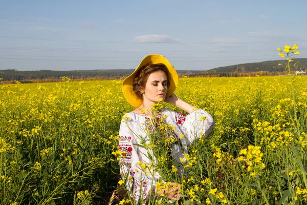 Flicka i en broderad skjorta bland blommande området — Stockfoto