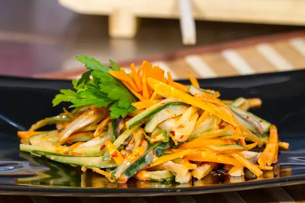 Üzerinde siyah bir tabak deniz ürünleri ile sebze salatası