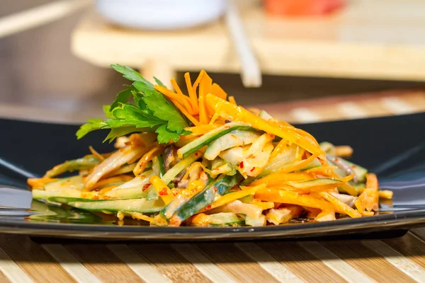 Üzerinde siyah bir tabak deniz ürünleri ile sebze salatası