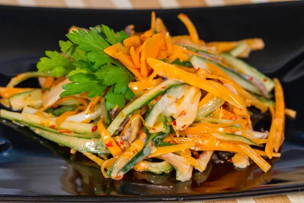 Üzerinde siyah bir tabak deniz ürünleri ile sebze salatası