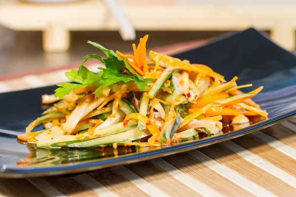 Üzerinde siyah bir tabak deniz ürünleri ile sebze salatası