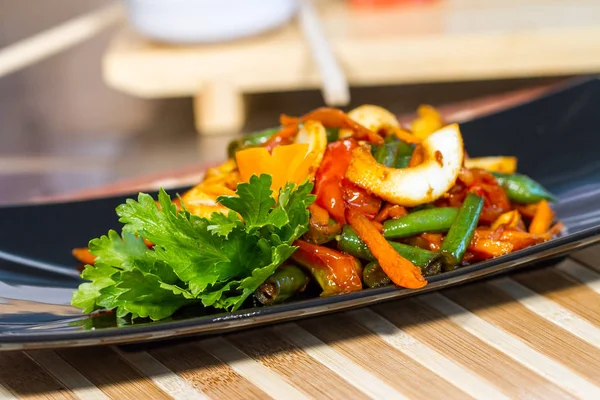 Üzerinde siyah bir tabak deniz ürünleri ile sebze salatası