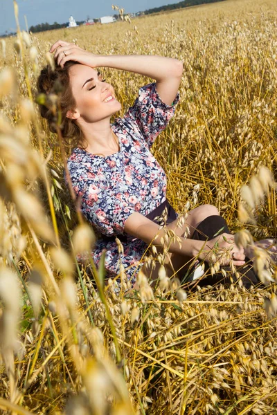 Jeune paysanne assise dans un champ au milieu des oreilles mûres — Photo