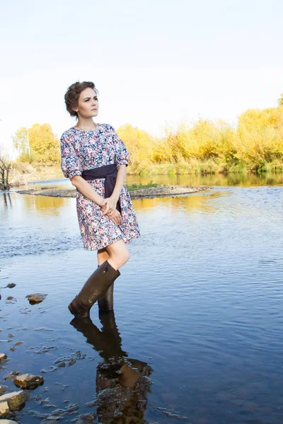 Стройная молодая девушка стоит на берегу реки — стоковое фото