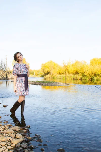 細身の若い女の子が川の土手の上に立つ — ストック写真