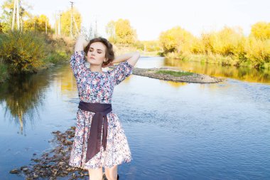 ince genç kız nehir kıyısında duruyor