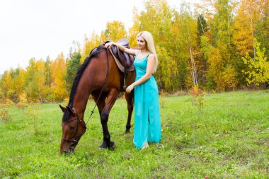 Sonbahar bir ormanda yürüyüş bir at ile kız