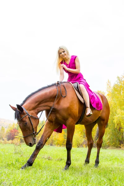 Fille avec un cheval marchant dans une forêt d'automne — Photo