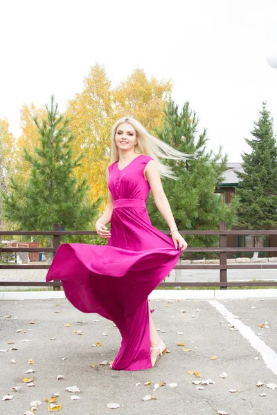 Vacker blondin i en lång aftonklänning — Stockfoto