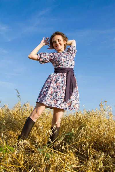 Dziewczynka stoi w polu przeciw błękitne niebo bezchmurne — Zdjęcie stockowe