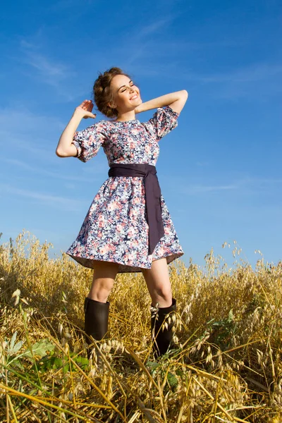 Dziewczynka stoi w polu przeciw błękitne niebo bezchmurne — Zdjęcie stockowe