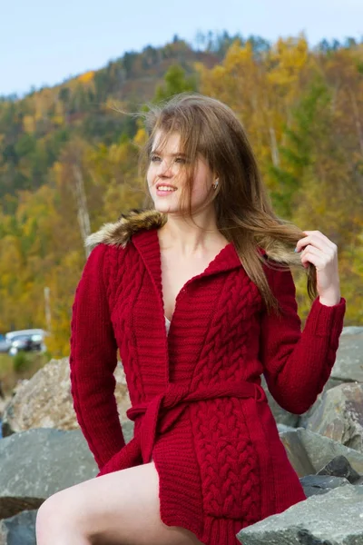Young girl in a red cardigan against a background of autumn leaves — Stock Photo, Image
