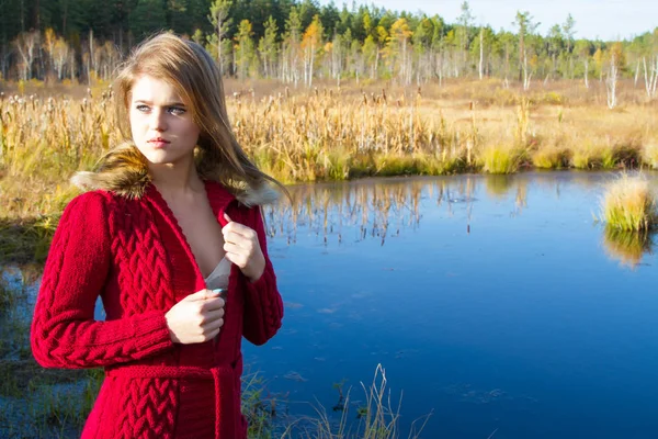 Девушка в красном кардигане на фоне осеннего пейзажа — стоковое фото