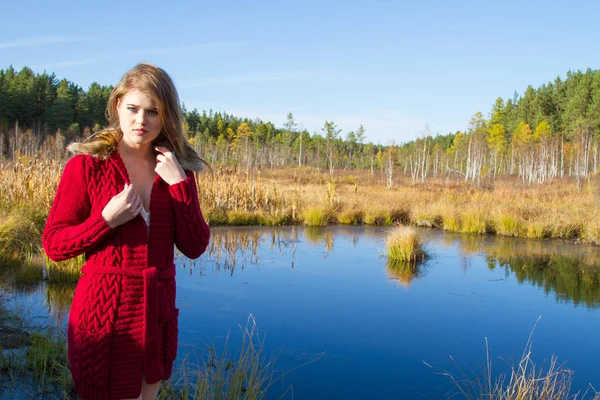 Giovane ragazza in cardigan rosso sullo sfondo del paesaggio autunnale — Foto Stock