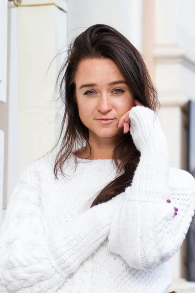 Chica joven en suéter blanco en el fondo del edificio — Foto de Stock