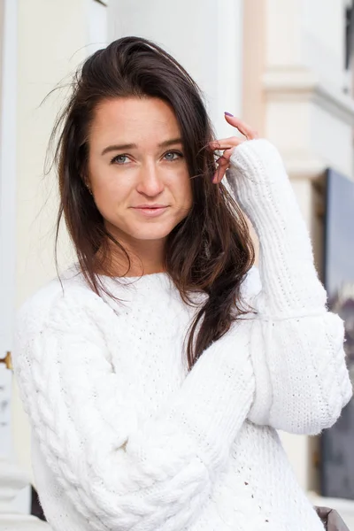 Menina jovem em suéter branco no fundo do edifício — Fotografia de Stock