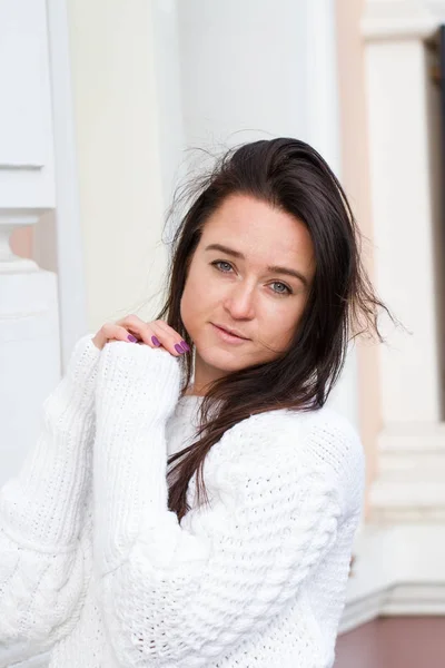 Menina jovem em suéter branco no fundo do edifício — Fotografia de Stock