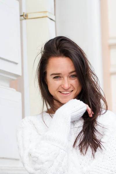 Young girl in white sweater on building background — Stock Photo, Image