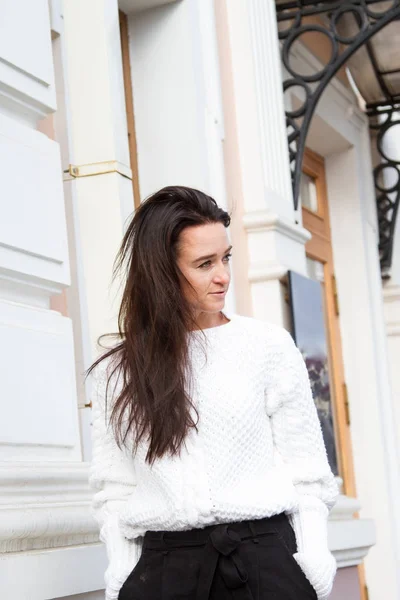 Young girl in white sweater on building background — Stock Photo, Image